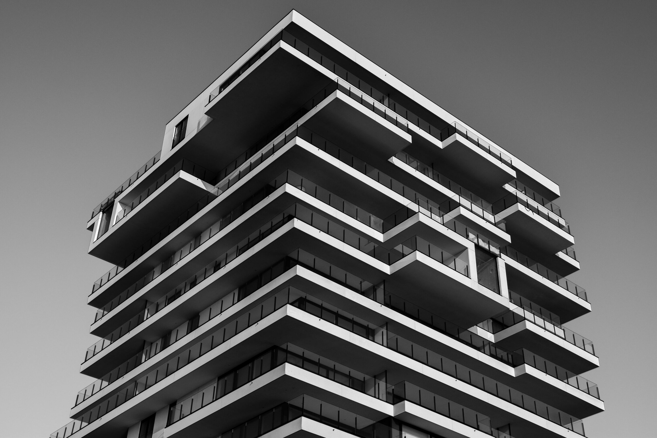 Home A striking black and white photo of a modern high-rise building with unique geometric designs.
